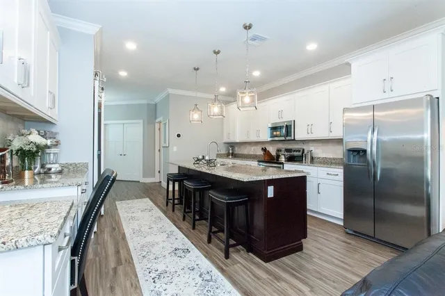 a kitchen with kitchen island granite countertop a sink stove and refrigerator