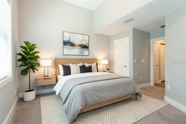 a bedroom with a bed and a potted plant