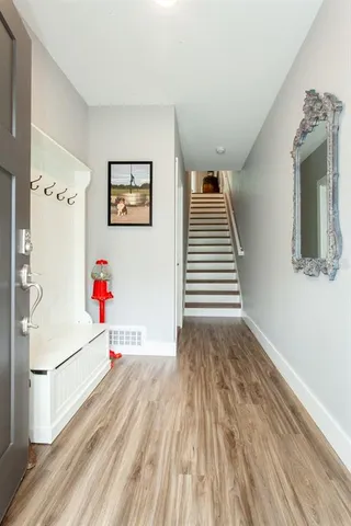 a view of a hallway with wooden floor and entryway