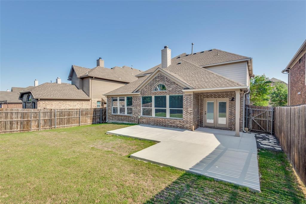 2344 Ranchview Drive Little Elm, TX 75068 - Photo 23 of 24 Expansive backyard featuring a large concrete patio, double-pane glass doors, and a full brick exterior