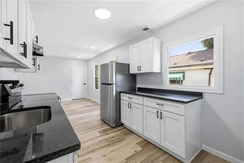 a kitchen with stainless steel appliances granite countertop a sink stove and refrigerator
