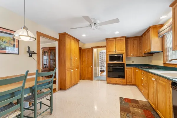 a large kitchen with stainless steel appliances granite countertop a stove refrigerator and a sink