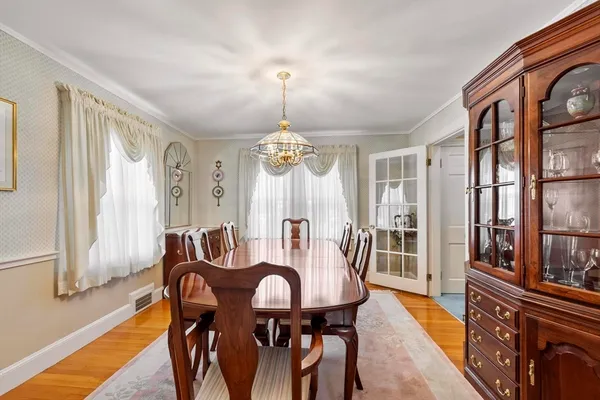 a view of a a dining room with furniture window and wooden floor