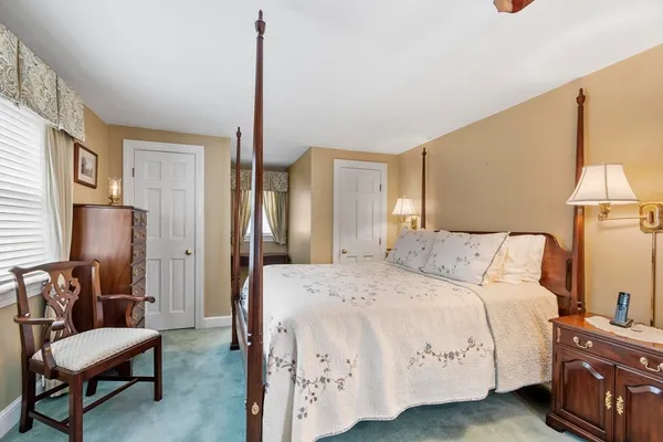 a bedroom with a bed a lamp and a closet