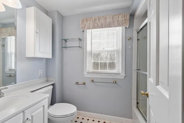 a bathroom with a sink a toilet and shower