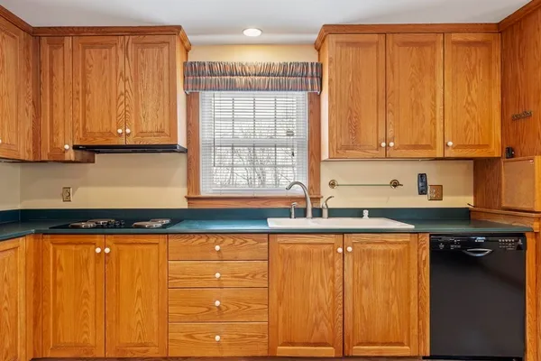 a kitchen with granite countertop wooden cabinets and a sink