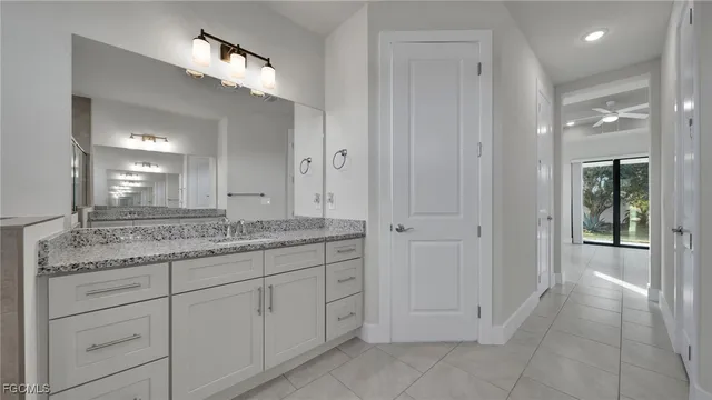 a bathroom with a granite countertop sink a mirror and a vanity