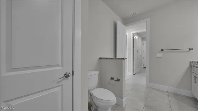 a bathroom with a granite countertop toilet and a shower