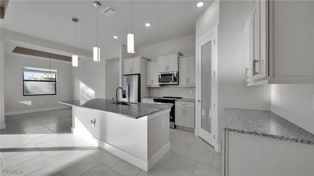 a kitchen with stainless steel appliances granite countertop a sink and a stove
