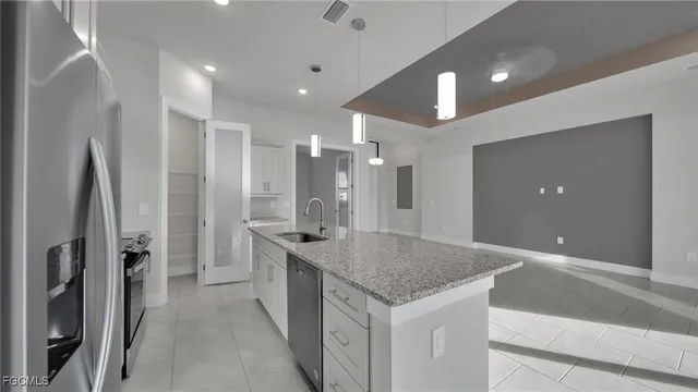 a kitchen with stainless steel appliances granite countertop kitchen island a refrigerator and a sink