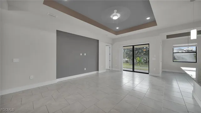 a view of an empty room with glass door and chandelier
