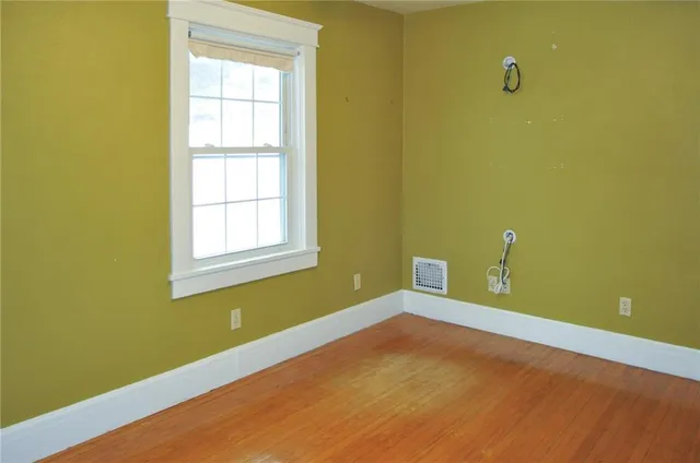 a view of an empty room with a window and a ceiling fan