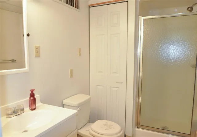 a bathroom with a sink a toilet and shower