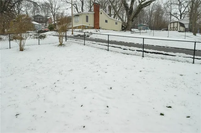 a view of a yard with snow on the road