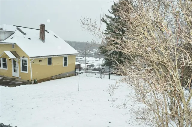 a view of a house with a snow in the yard