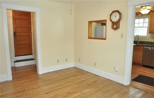 a view of empty room with wooden floor and window