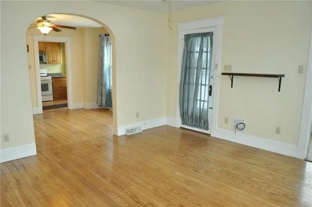 an empty room with wooden floor and a mirror