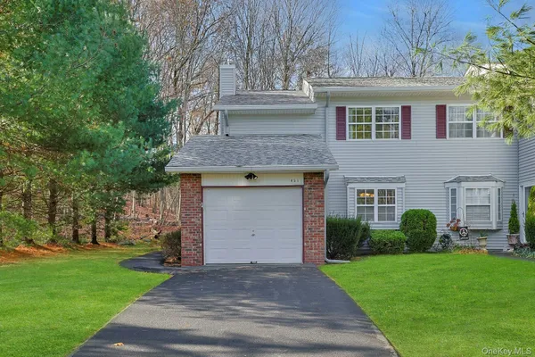 a front view of a house with a garden and yard