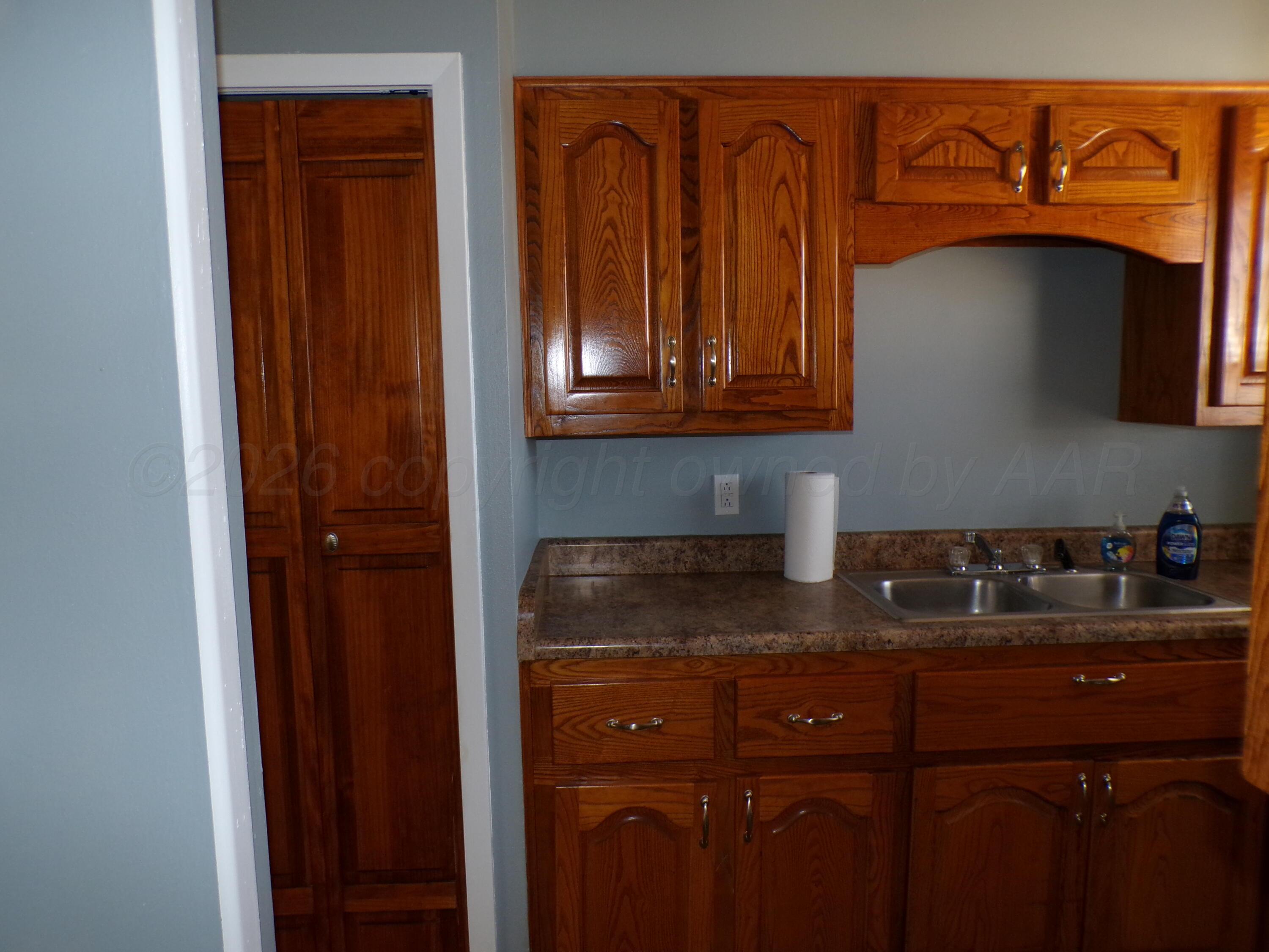403 North Robey Avenue Fritch, TX 79036 - Photo 16 of 24 a kitchen with stainless steel appliances granite countertop a sink stove and cabinets