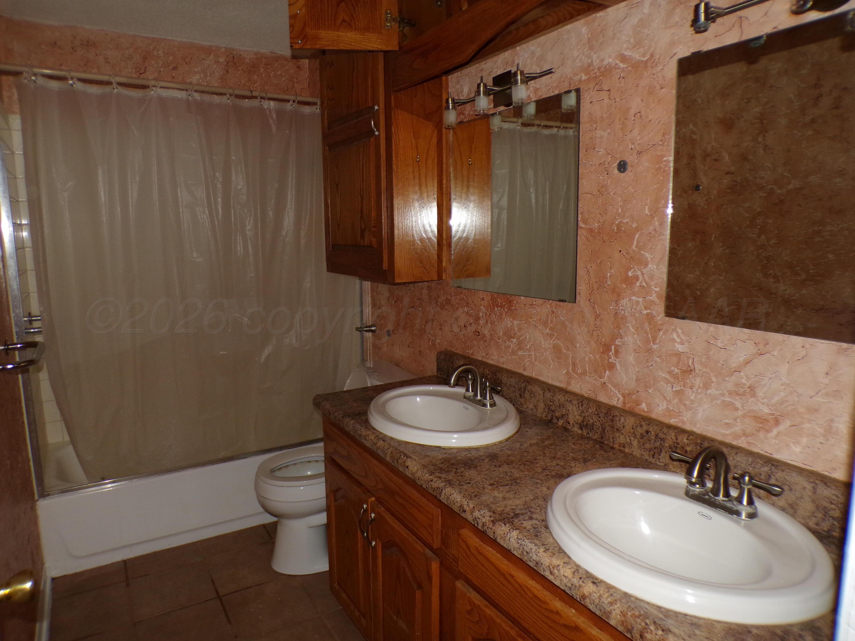 403 North Robey Avenue Fritch, TX 79036 - Photo 17 of 24 a bathroom with a sink a toilet and shower