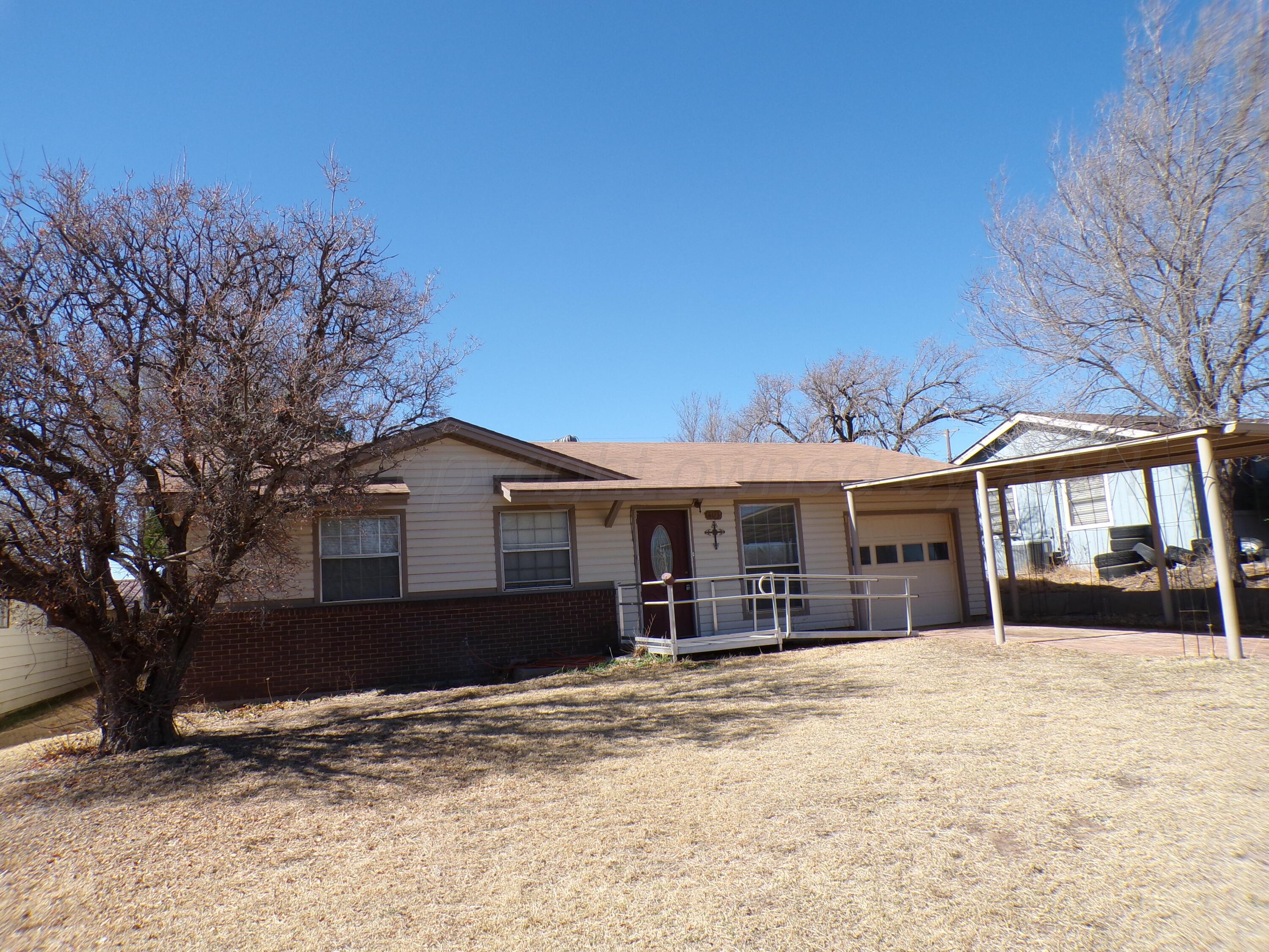 403 North Robey Avenue Fritch, TX 79036 - Photo 4 of 24 a front view of a house with a yard covered in snow
