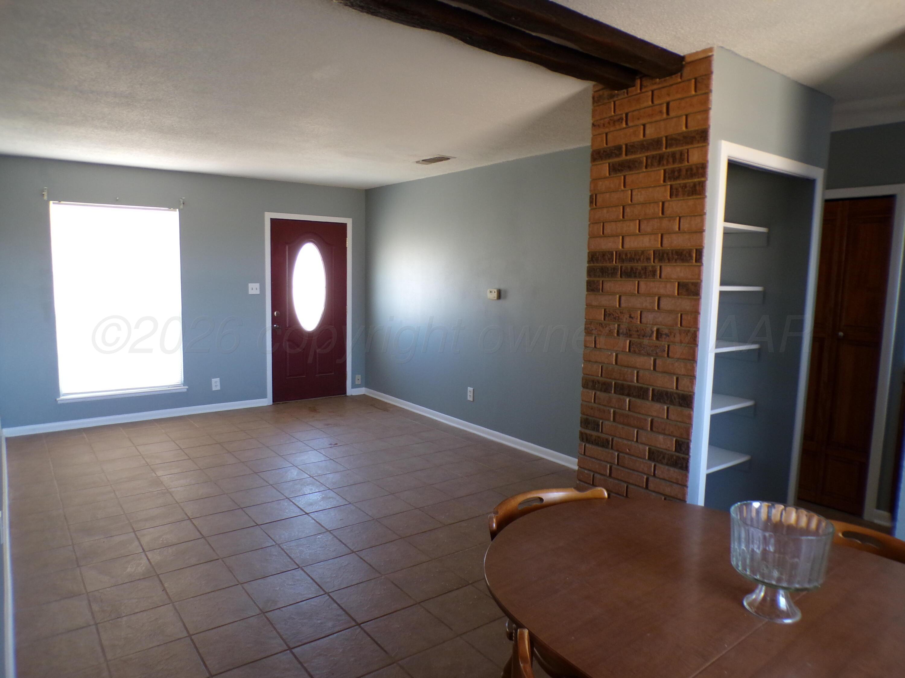 403 North Robey Avenue Fritch, TX 79036 - Photo 8 of 24 a view of an empty room with window and wooden floor