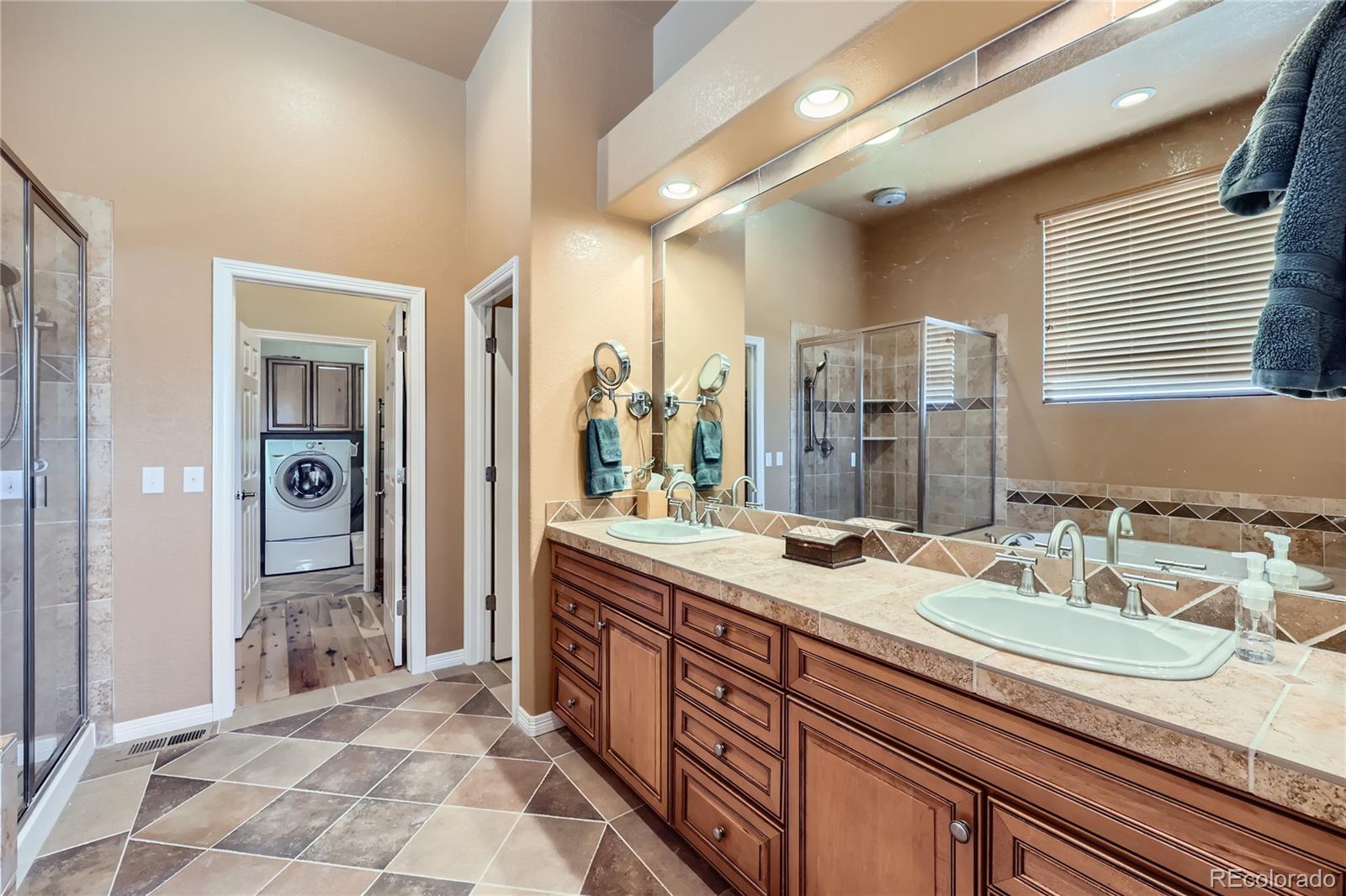 7009 Winter Ridge Place Castle Pines, CO 80108 - Photo 18 of 42 a spacious bathroom with a granite countertop sink and a mirror