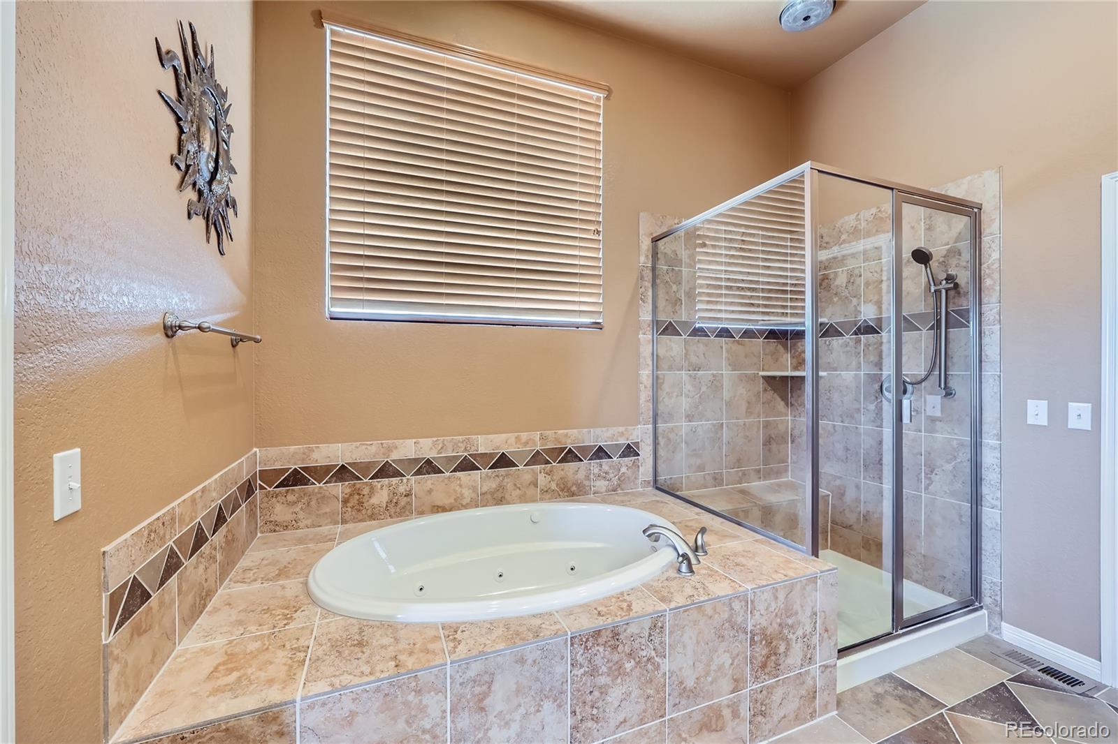 7009 Winter Ridge Place Castle Pines, CO 80108 - Photo 20 of 42 a bathroom with a bathtub and shower