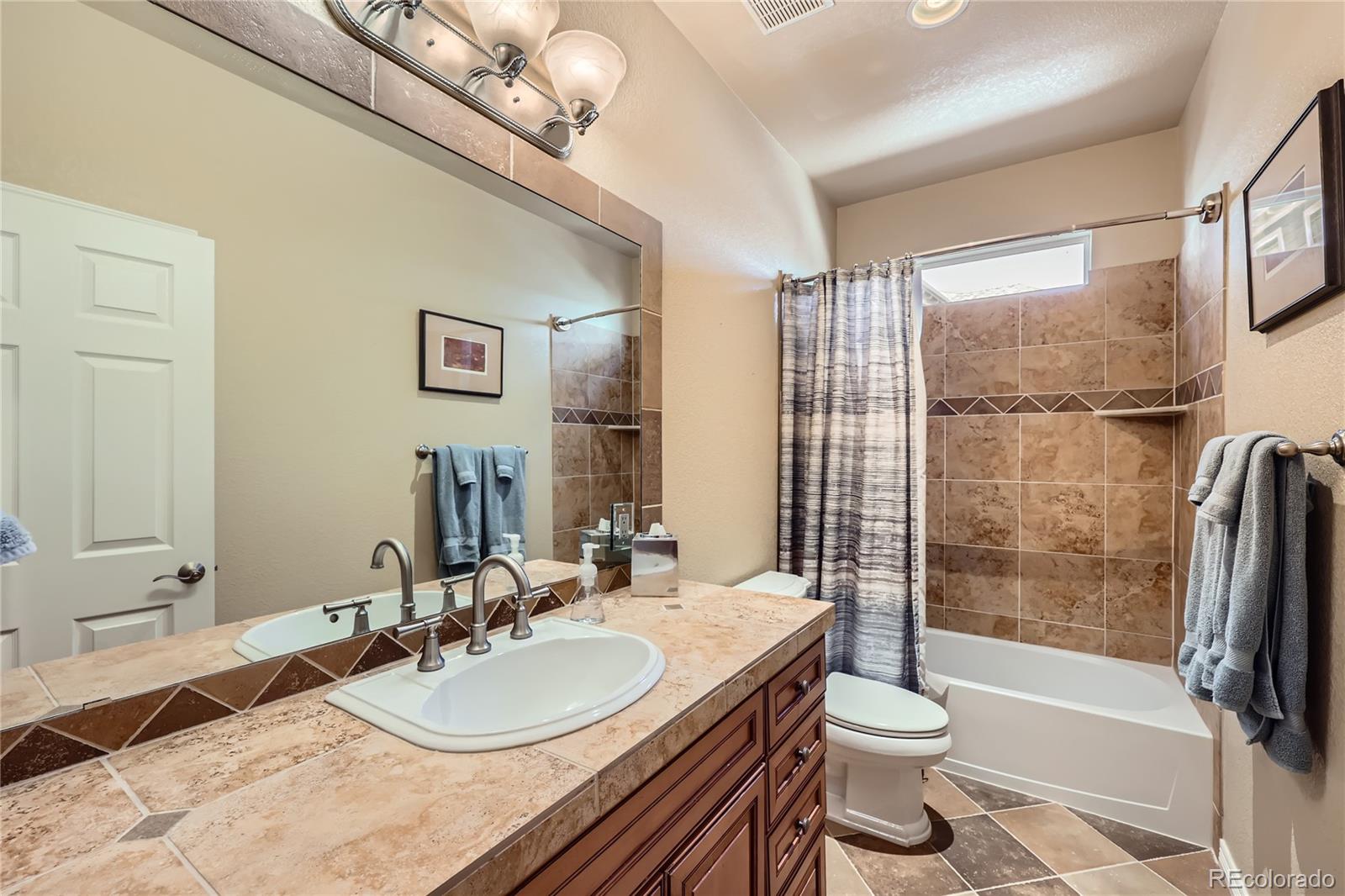 7009 Winter Ridge Place Castle Pines, CO 80108 - Photo 22 of 42 a bathroom with a granite countertop sink toilet and shower