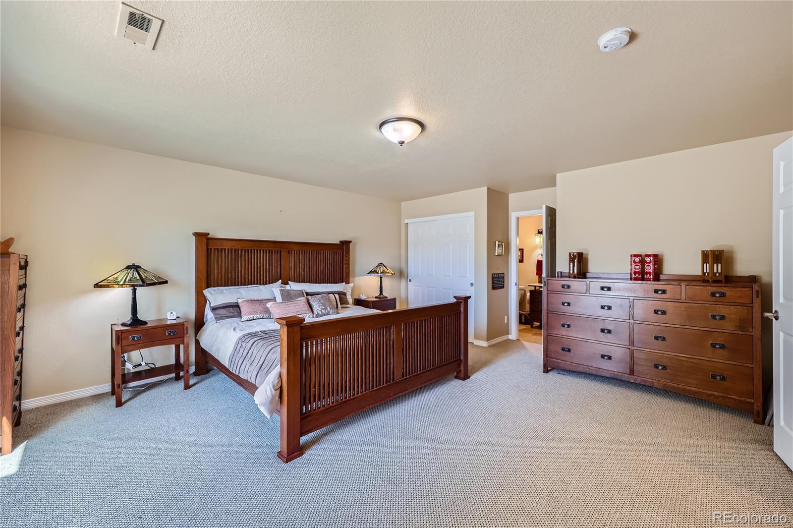 7009 Winter Ridge Place Castle Pines, CO 80108 - Photo 32 of 42 a bed room with a bed and a dresser