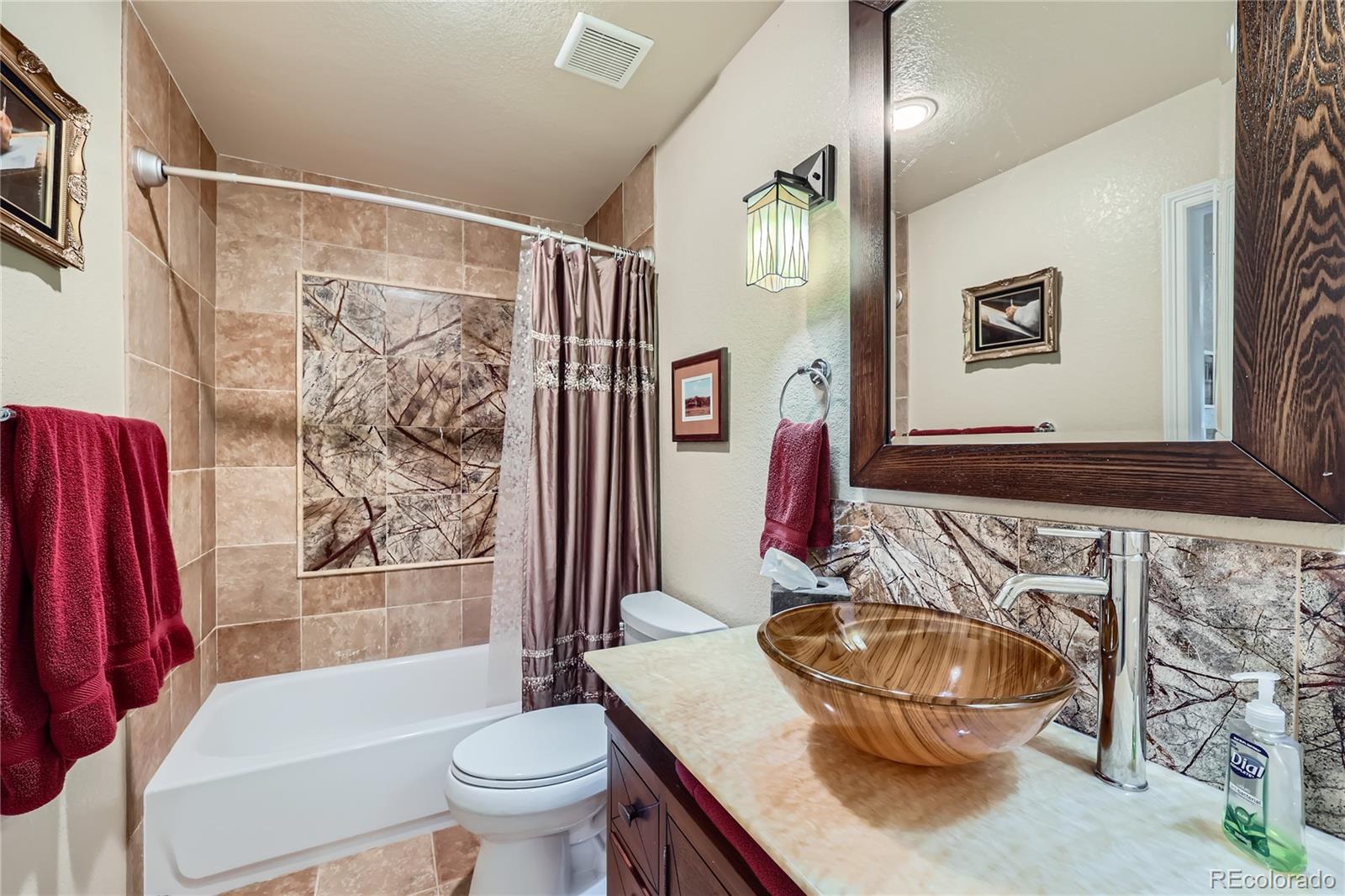 7009 Winter Ridge Place Castle Pines, CO 80108 - Photo 33 of 42 a bathroom with a sink a toilet and a mirror