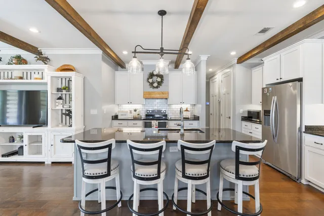 a kitchen with kitchen island granite countertop a sink cabinets and stainless steel appliances