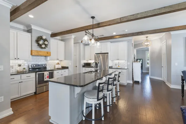 a kitchen with granite countertop cabinets stainless steel appliances and wooden floor