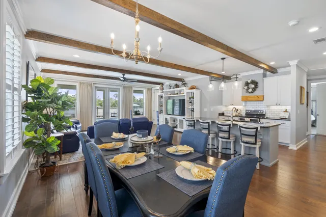 a kitchen with a dining table chairs sink and wooden floor