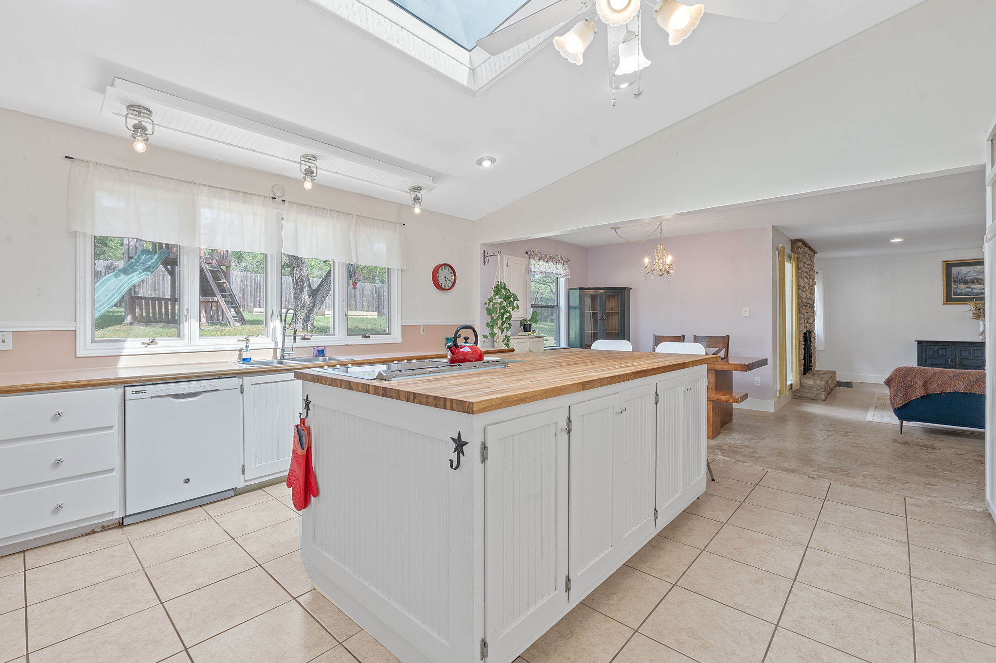 8705 South View Road Austin, TX 78737 - Photo 10 of 39 Functional Kitchen Layout with White Cabinetry, Butcher Block Countertops, and Natural Light from Skylight