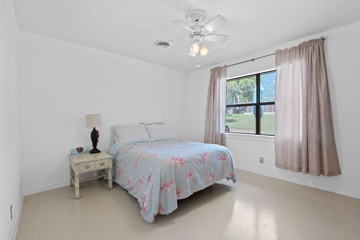 8705 South View Road Austin, TX 78737 - Photo 21 of 39 a bedroom with a bed and a large window