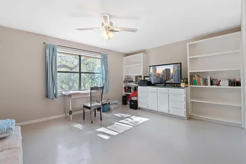 a view of a workspace with furniture and a window
