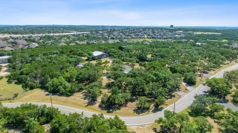 an aerial view of green landscape with trees houses and mountain view