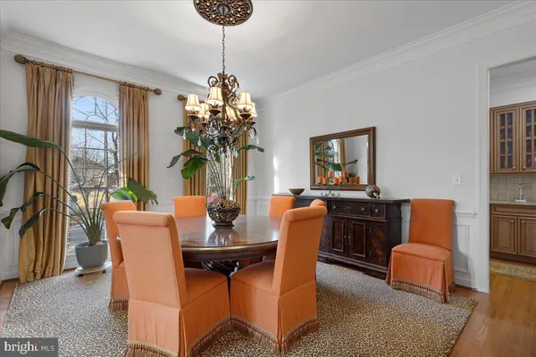 a kitchen with stainless steel appliances kitchen island granite countertop a table chairs stove and white cabinets