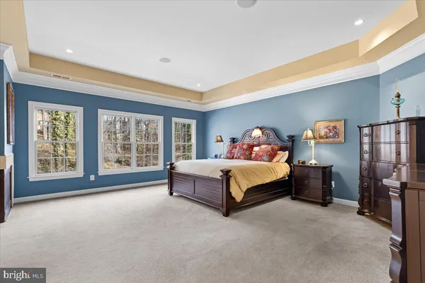 a spacious bedroom with a bed and wooden floor
