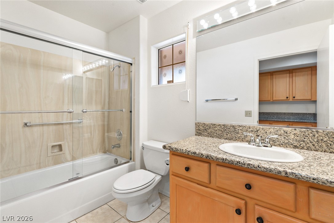 9433 Quail Ridge Drive Las Vegas, NV 89134 - Photo 19 of 25 This functional bathroom features a shower-tub combination, a vanity with granite counters, and a toilet.