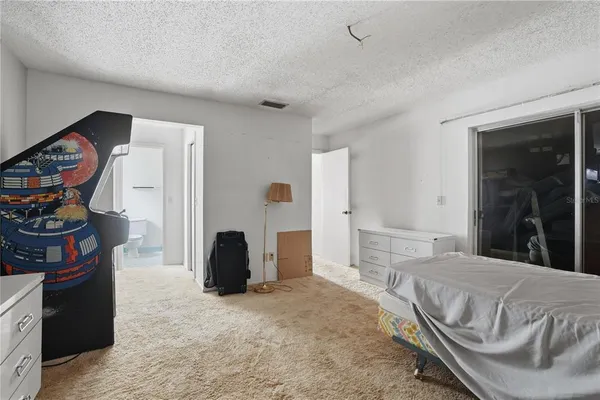 a spacious bedroom with a bed and a window