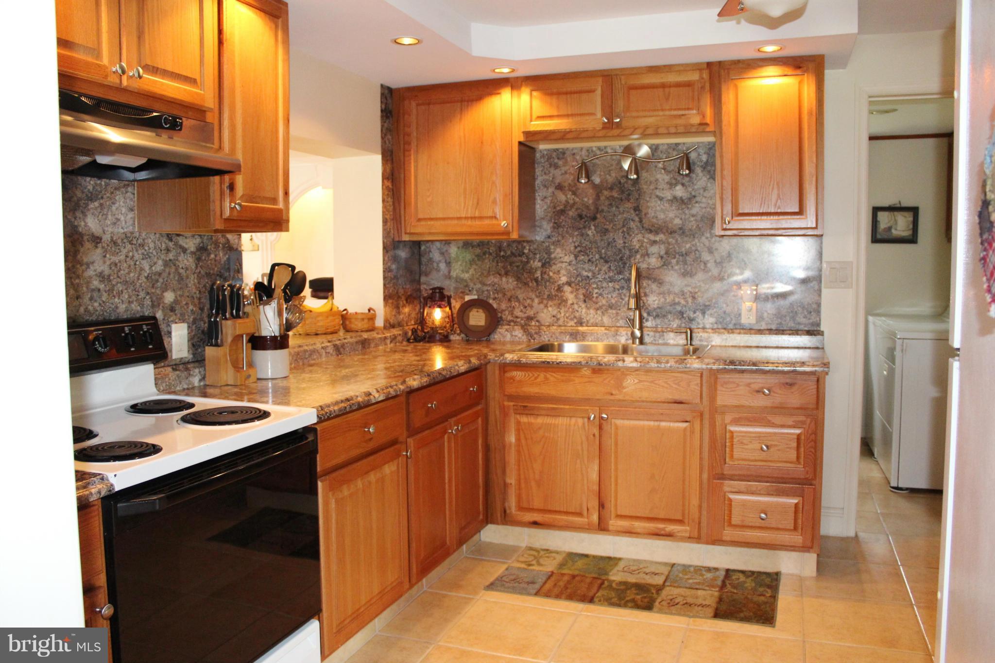 11191 Big Pool Road Big Pool, MD 21711 - Photo 10 of 30 a kitchen with stainless steel appliances granite countertop a sink stove and cabinets