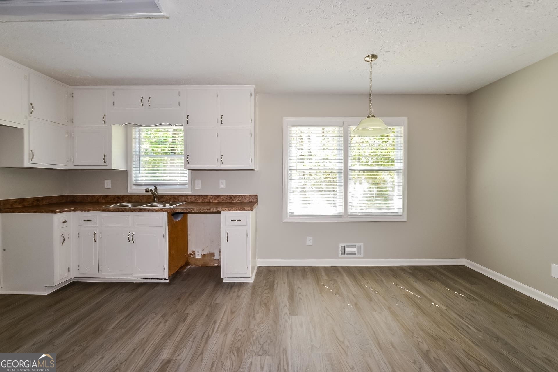 109 Landover Drive Stockbridge, GA 30281 - Photo 4 of 16 a kitchen with granite countertop wooden floors white cabinets and window