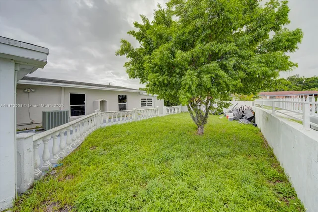 a view of an house with backyard and trees
