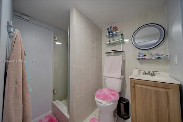 a living room with furniture a flat screen tv and a refrigerator