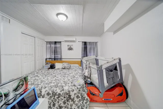 a spacious bedroom with a bed and a view of kitchen