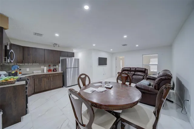 a living room with furniture a flat screen tv and a window
