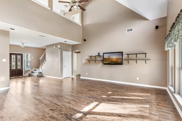 a view of a livingroom with wooden floor and a ceiling fan