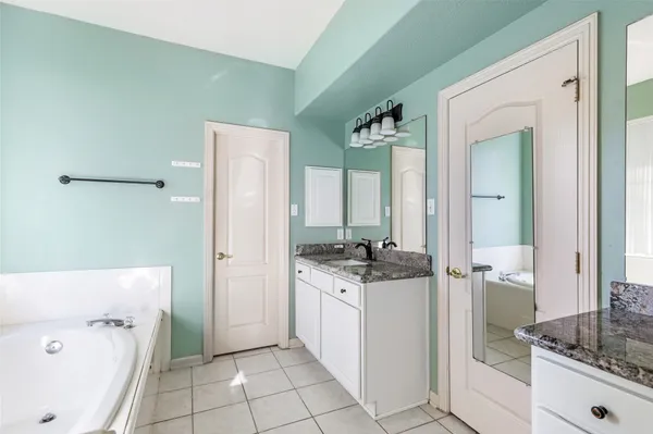 a bathroom with a granite countertop sink a toilet and a mirror